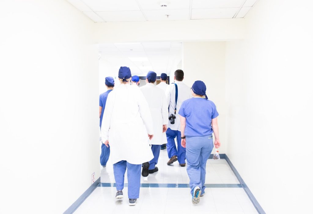 group of doctors and nurses heading towards a patient