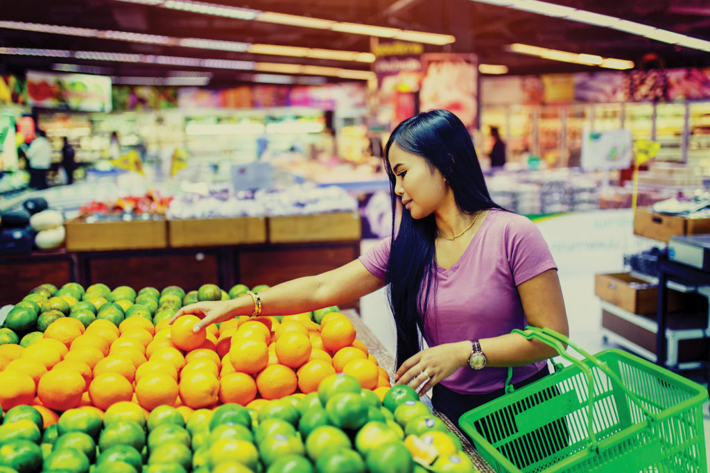 young woman Grocery Shopping and picking oranges