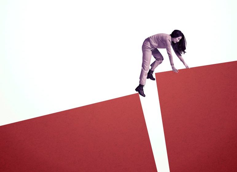 Woman climbing across large red boxes