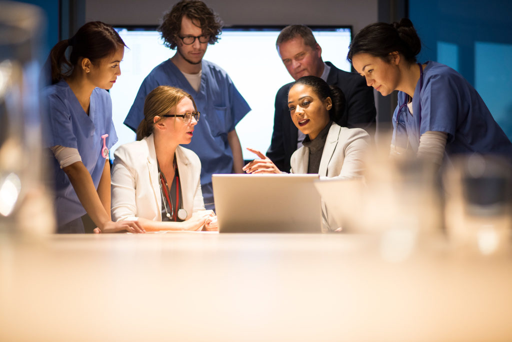 Group of health care professionals looking at computer