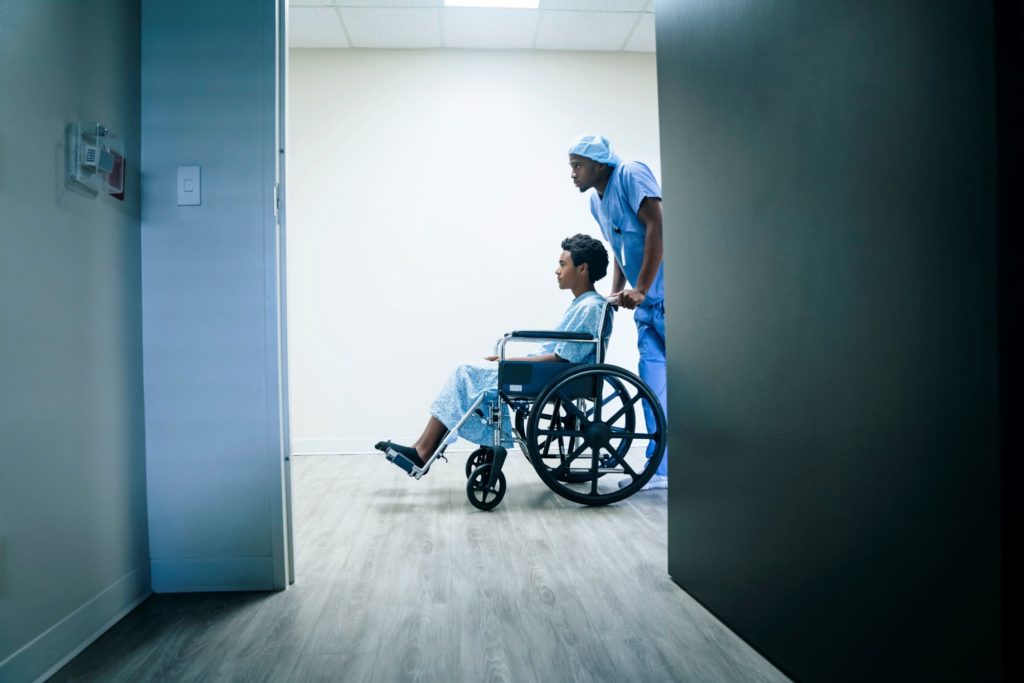 Male nurse pushing male patient in a wheelchair