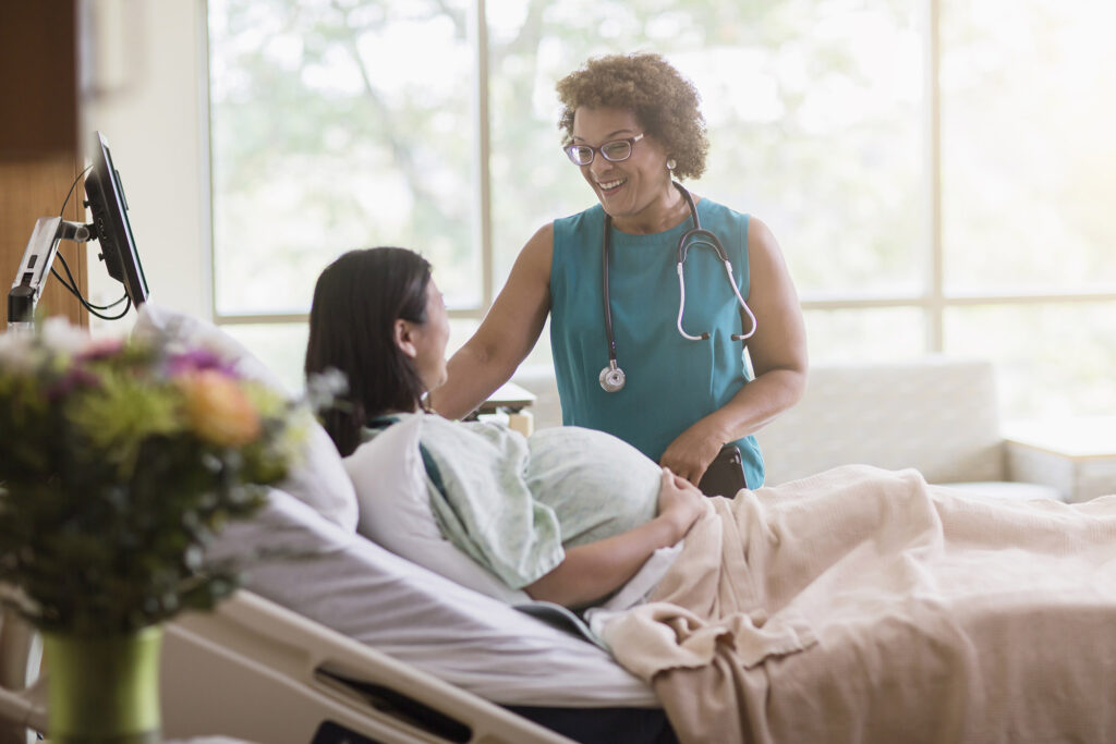 Doctor talking to pregnant patient in hospital room