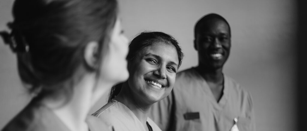 Happy multiracial male and female medical professionals in hospital